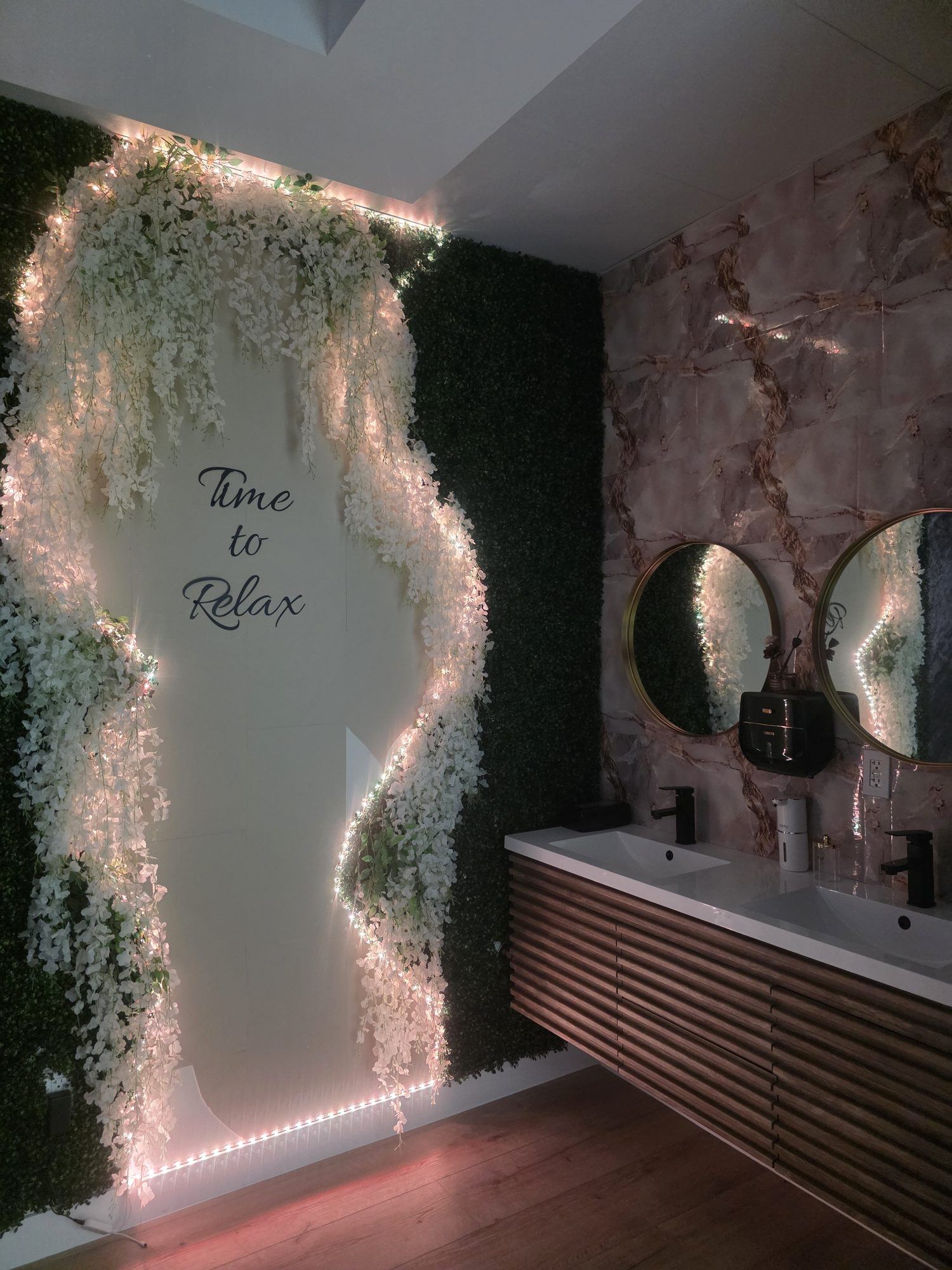 Stone sink surrounded by moss, fairy lights and wood slats