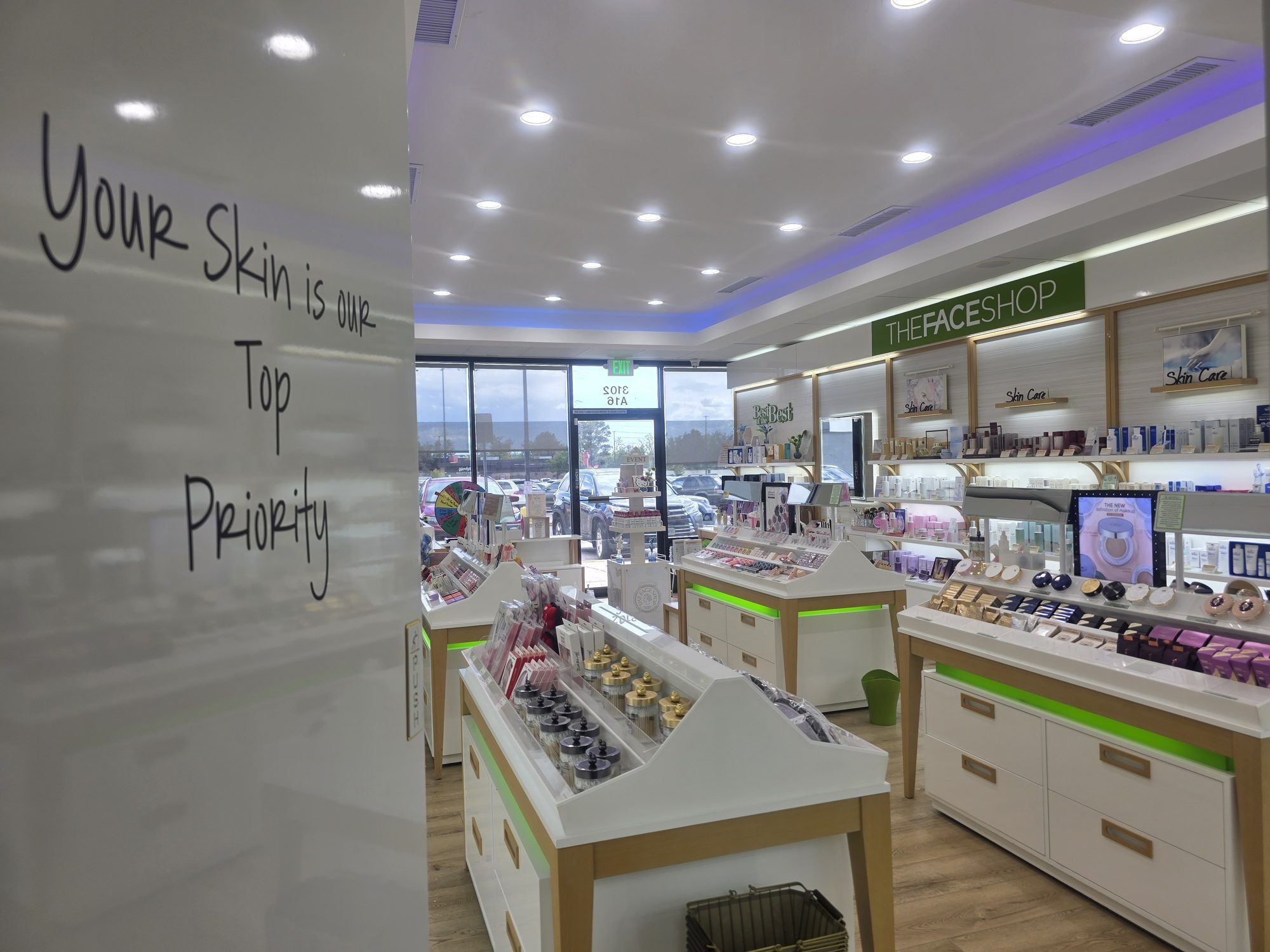 Glass door at the back of the shop with hand-lettered 'Your Skin is our Top Priority'